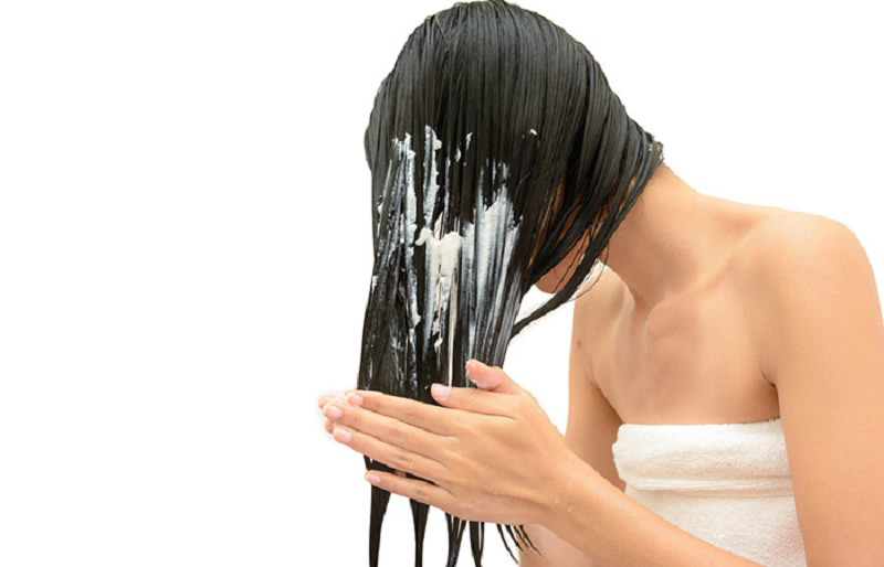 cô gái đang thoa dầu xả lên tóc