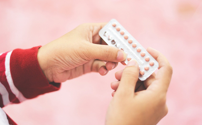 tay cầm vỉ thuốc tránh thai